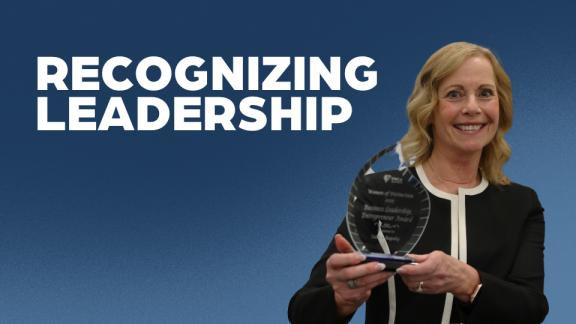 Tamra Rapsky poses with her Westman Women of Distinction Award in front of a blue background